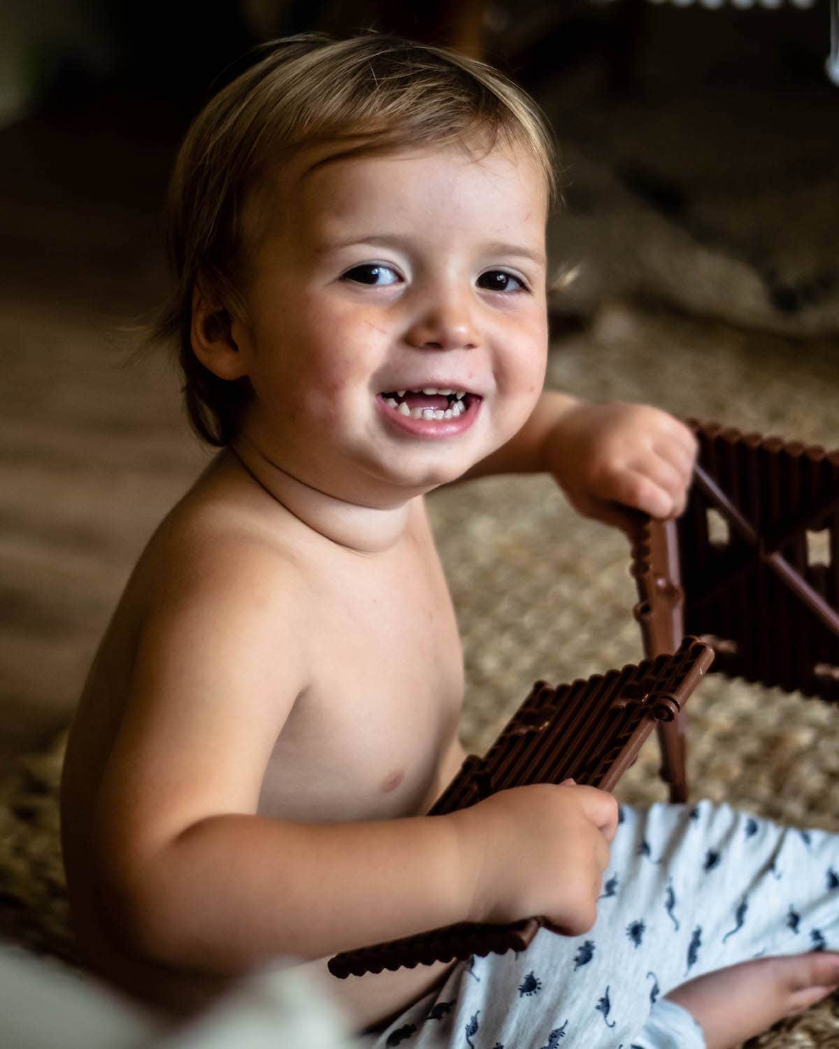 My smiling, brown haired, toddler playing.