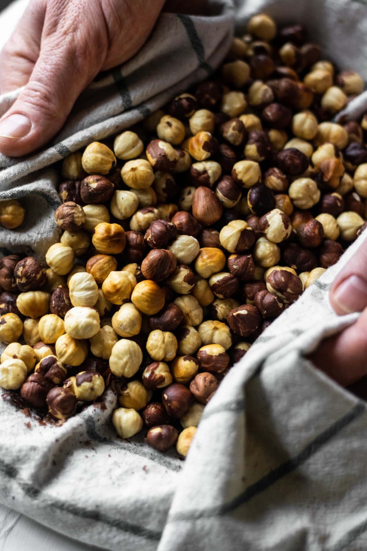 The roasted hazelnuts being rubbed in a tea towel to remove the skins.