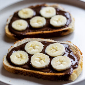 Two slices of toast, spread with Nutella and topped with sliced Banana.