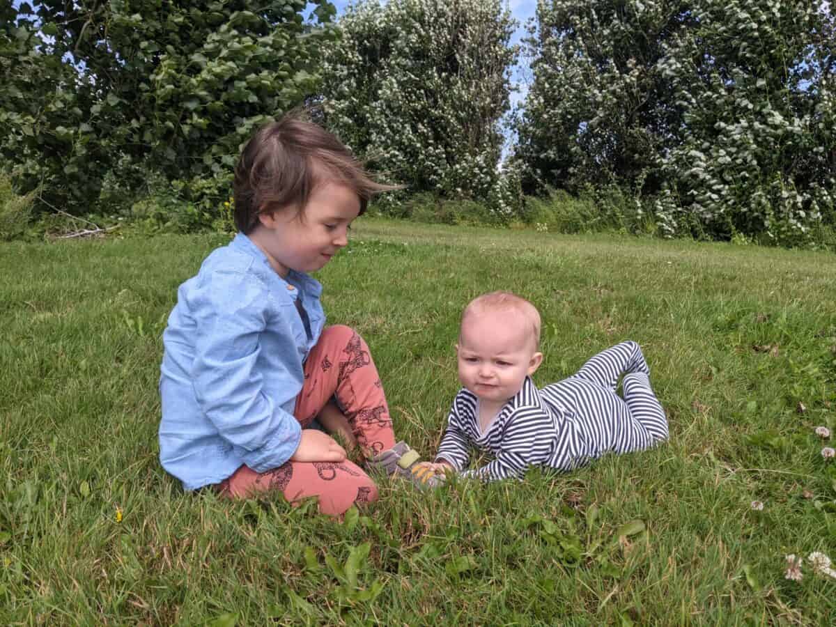 Our two children, sitting on the grass.