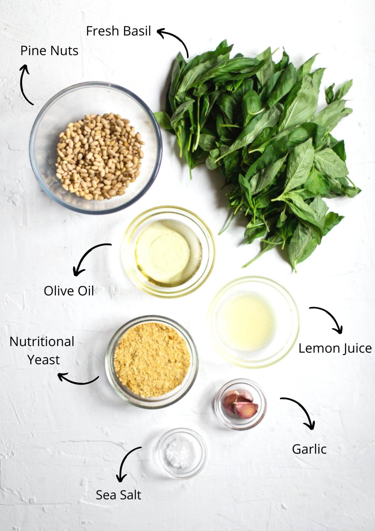 Ingredients for the vegan pesto on a white background.