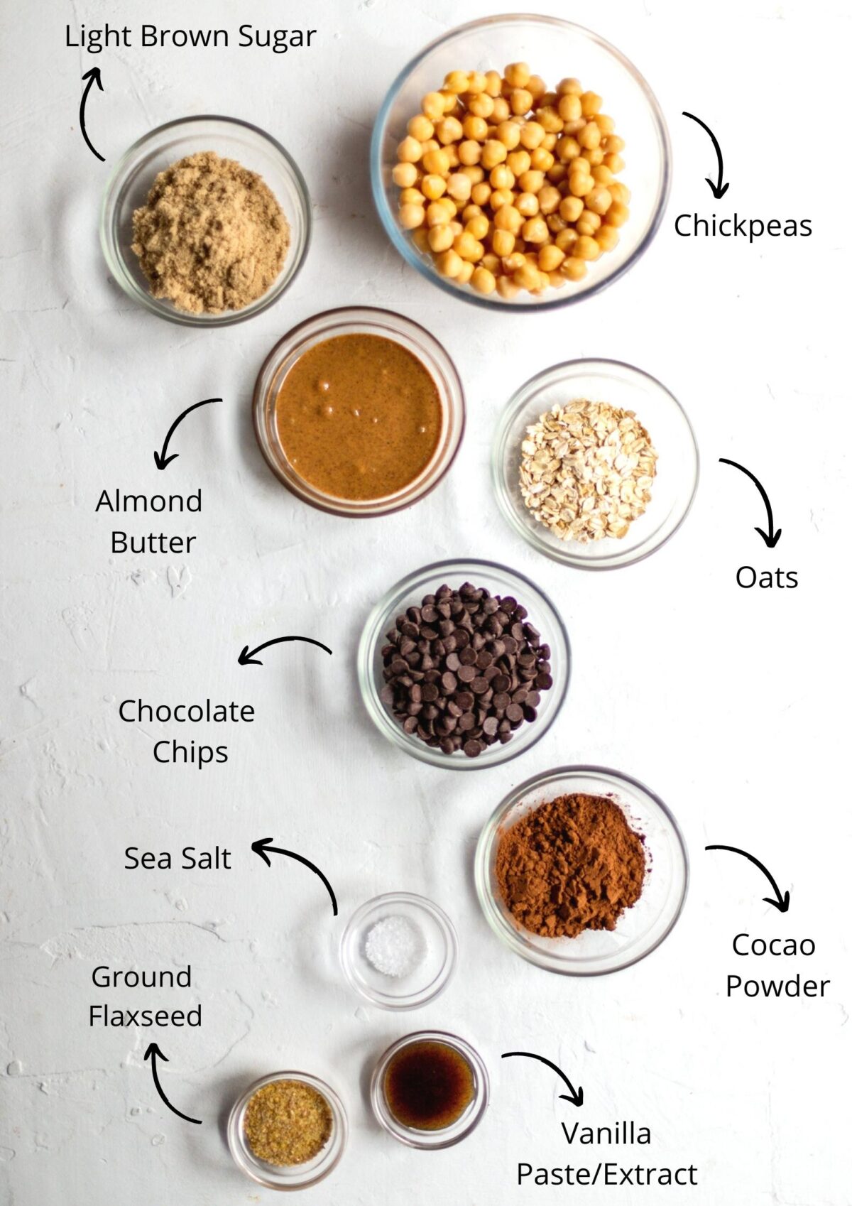 Double chocolate cookie dough ingredients, laid out in a white background, in glass bowls.