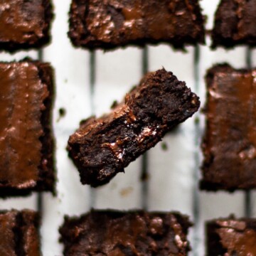 Blackbean brownies arranged on a cooling rack, with central brown on its side.