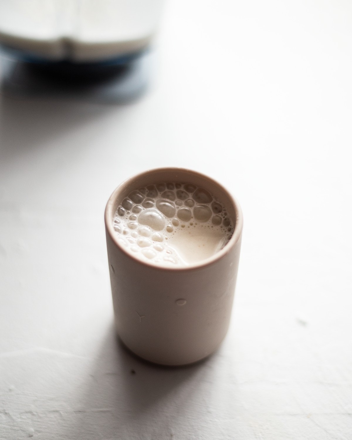 A photo of a childs cup, filled with cashew milk.