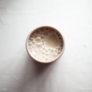An overhead photo of a childs cup, filled with cashew milk.