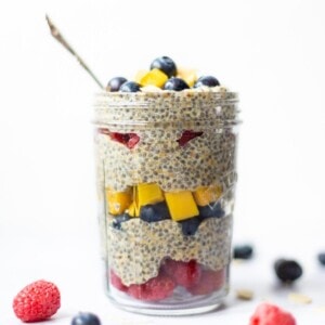 Chia and flaxseed pudding in a jar with spoon, on a white background.