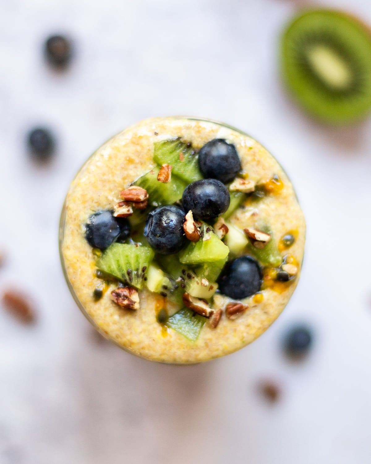 Fresh fruit and pecans on top of a jar of flaxseed pudding.