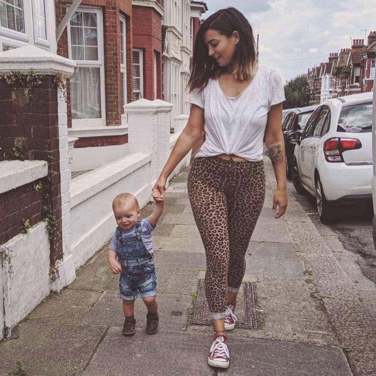 Yasmin and her son walking down the street, handing hand.